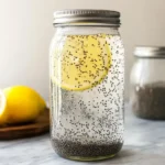 A mason jar filled with chia water and a lemon slice, showcasing a refreshing and healthy chia water recipe for hydration and wellness.